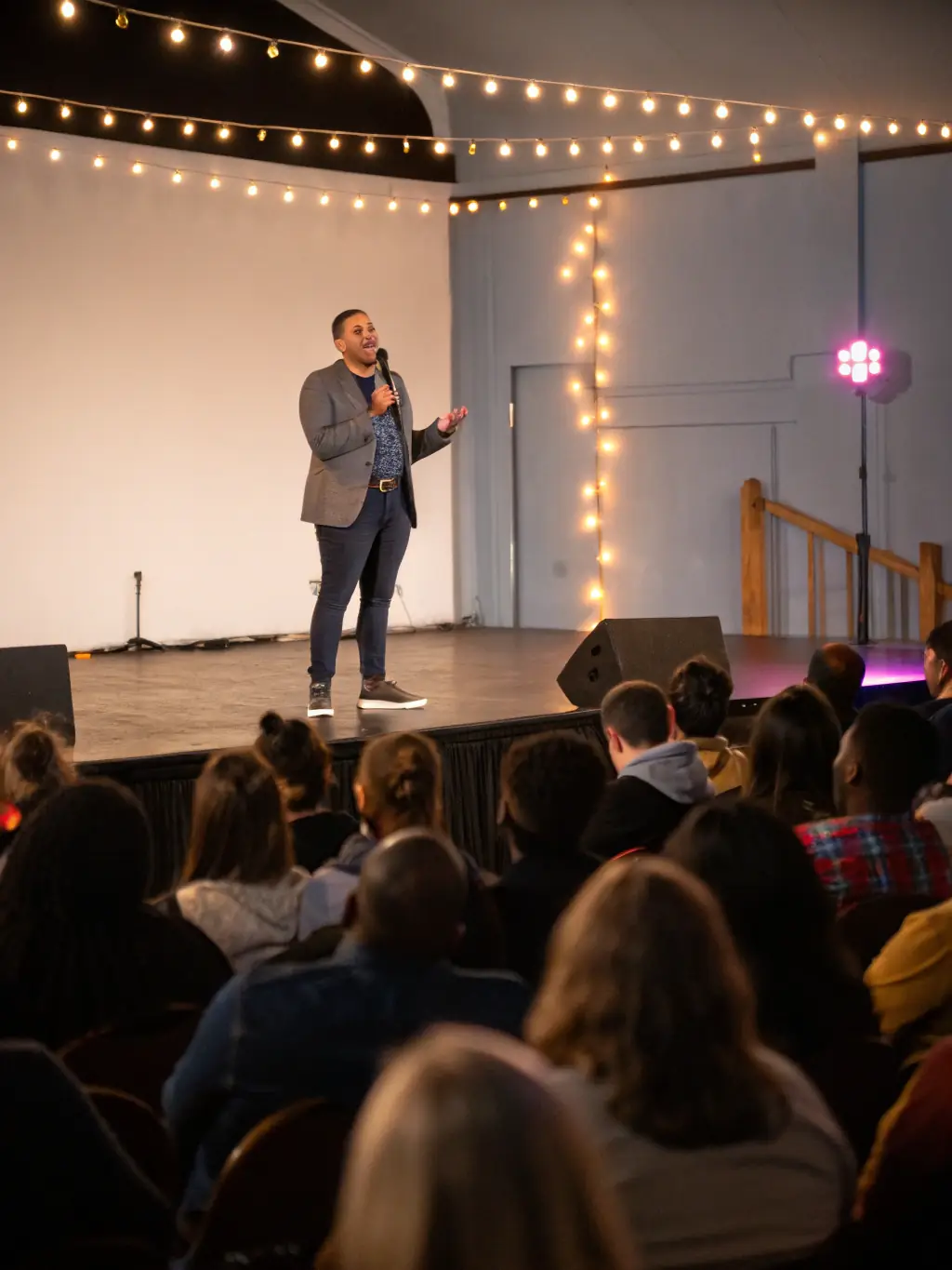 A professional shot of a conference in Birmingham, highlighting a speaker delivering a presentation on stage with engaging visuals.