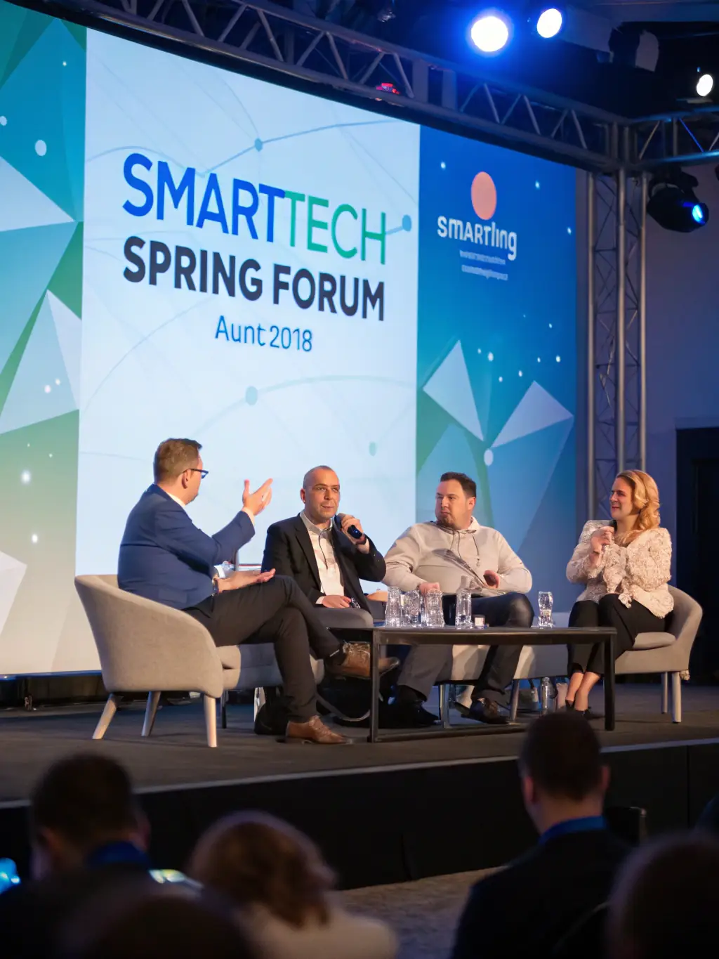 A vibrant photograph of a conference in London, showcasing a panel discussion with diverse speakers and a modern, well-lit venue.